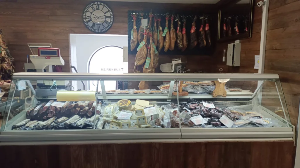 Frente de local con heladera expositora y fiambres de cerdo de fondo